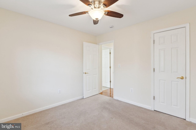 unfurnished bedroom with ceiling fan and light colored carpet