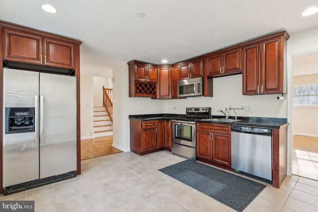 kitchen with light tile patterned flooring, appliances with stainless steel finishes, and sink