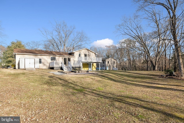 rear view of property with a yard, a storage unit, and a wooden deck