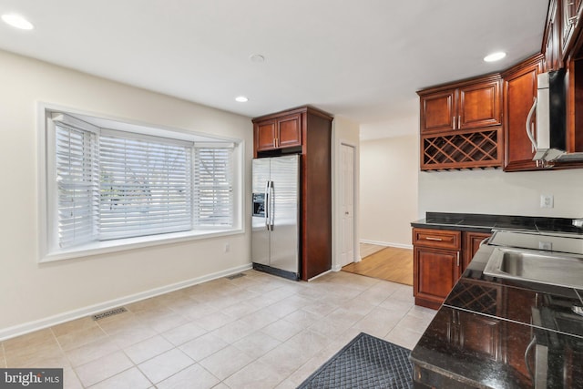 kitchen featuring stainless steel fridge, sink, and light tile patterned floors