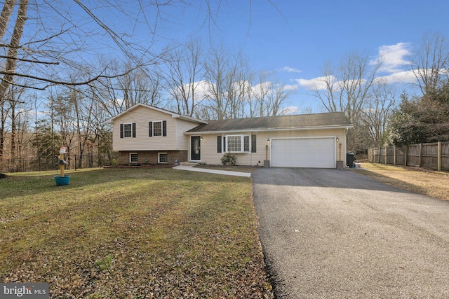 tri-level home featuring a garage and a front lawn