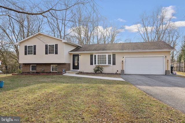 tri-level home featuring a garage and a front lawn