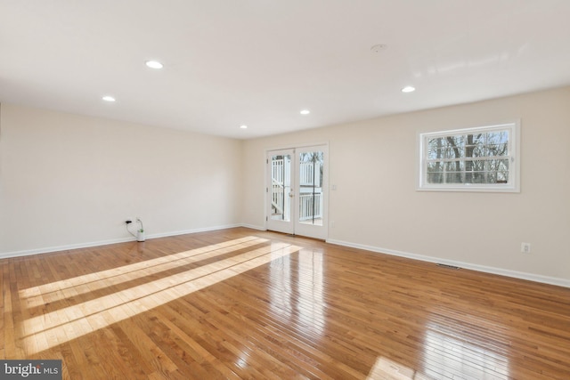 unfurnished room featuring french doors, light hardwood / wood-style flooring, and plenty of natural light