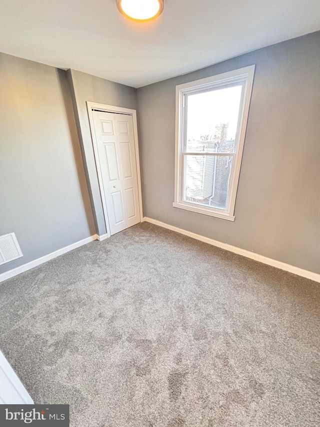 unfurnished bedroom with carpet flooring and a closet