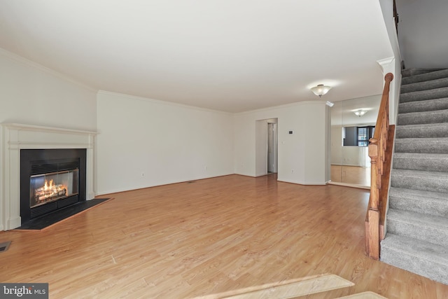 unfurnished living room with crown molding and light hardwood / wood-style flooring