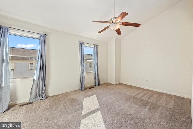 spare room with light carpet, vaulted ceiling, and ceiling fan