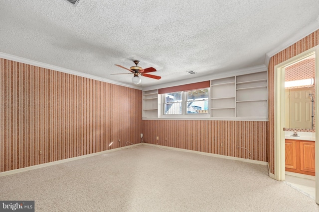 carpeted empty room with ceiling fan and a textured ceiling