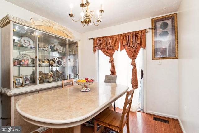 dining space featuring hardwood / wood-style flooring, plenty of natural light, and a chandelier