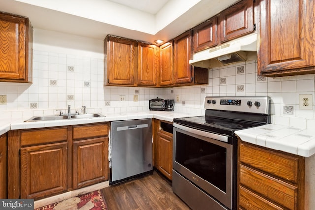 kitchen featuring dark hardwood / wood-style flooring, sink, appliances with stainless steel finishes, and tasteful backsplash