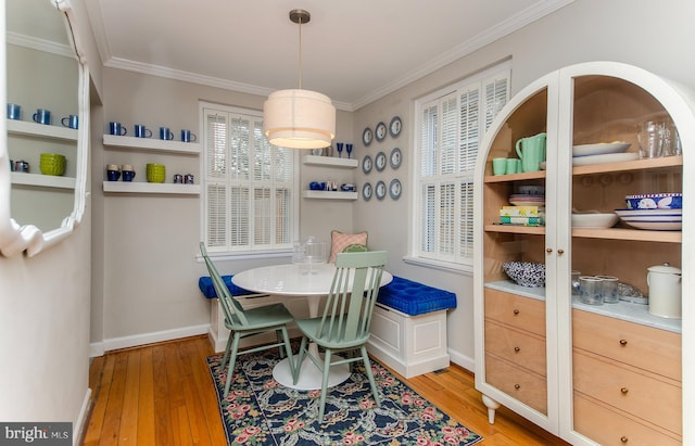 dining space with light wood-type flooring and crown molding