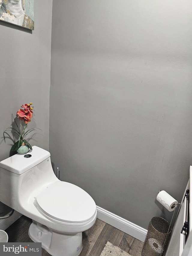 bathroom with hardwood / wood-style flooring and toilet