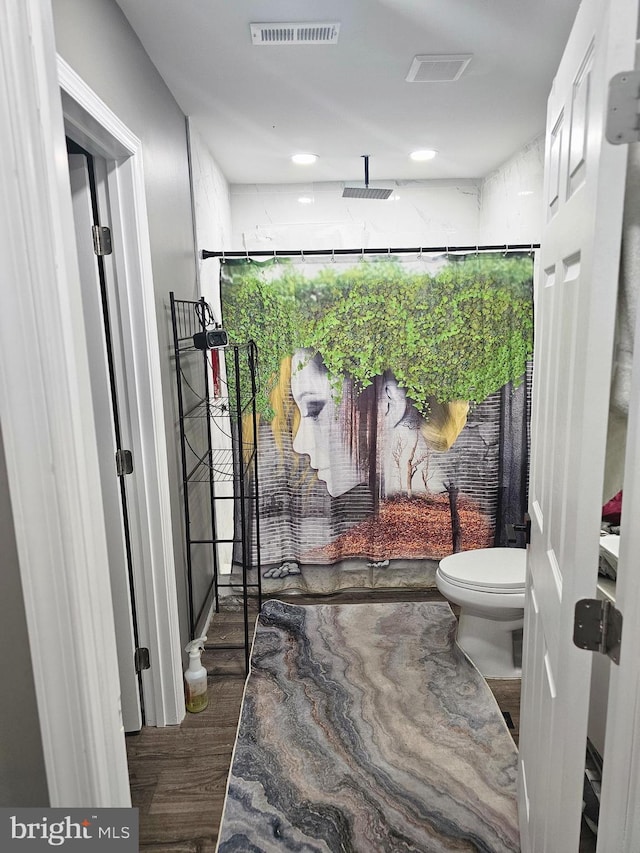 bathroom with walk in shower, wood-type flooring, and toilet