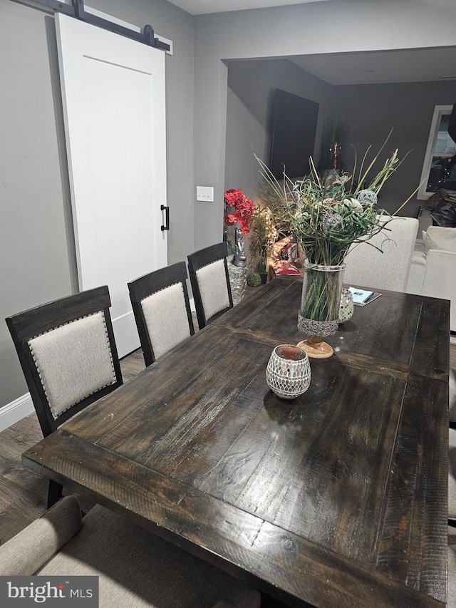 dining room featuring a barn door and hardwood / wood-style floors