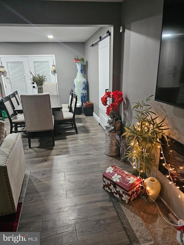 dining area with hardwood / wood-style flooring, a barn door, and french doors