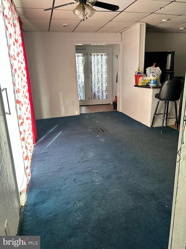 carpeted empty room featuring a paneled ceiling and ceiling fan