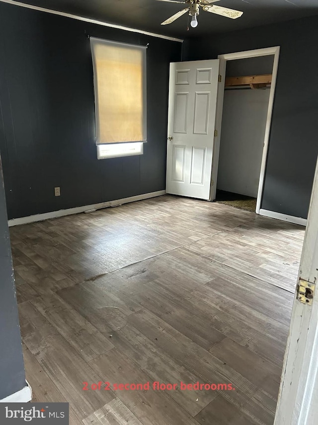 unfurnished bedroom with ceiling fan, a closet, and hardwood / wood-style flooring