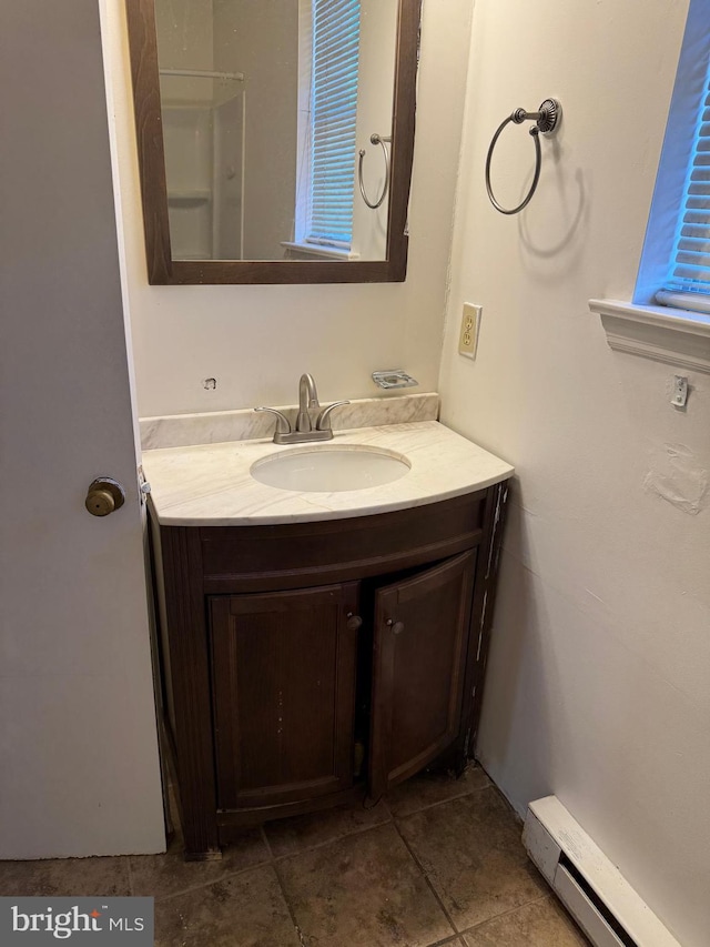 bathroom featuring tile patterned flooring, vanity, and a baseboard heating unit