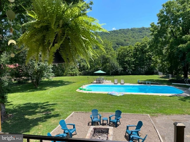 view of swimming pool featuring a fire pit, a diving board, a patio area, and a lawn