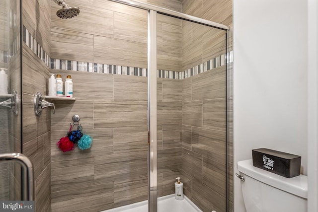 bathroom with toilet and a shower with door