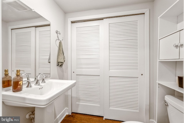 bathroom featuring hardwood / wood-style floors, toilet, and sink