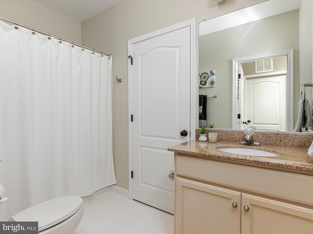 bathroom with tile patterned flooring, vanity, and toilet