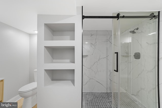 bathroom featuring built in shelves, hardwood / wood-style flooring, toilet, and an enclosed shower