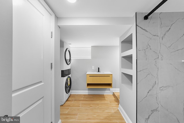 laundry room featuring stacked washing maching and dryer and hardwood / wood-style flooring