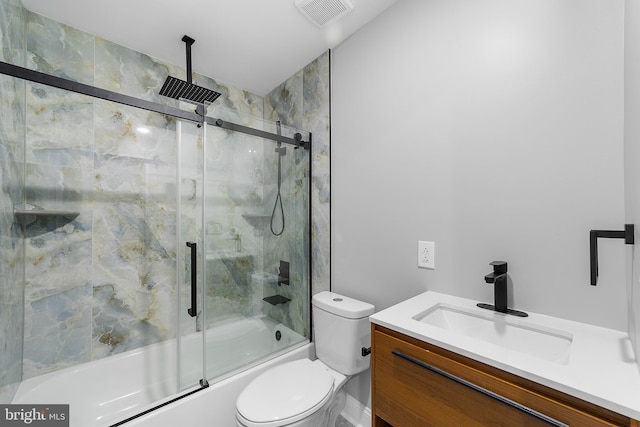 full bathroom with combined bath / shower with glass door, vanity, and toilet