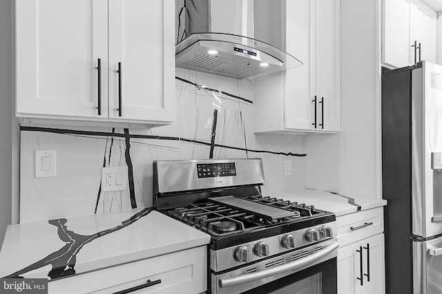 kitchen featuring decorative backsplash, white cabinets, stainless steel appliances, and wall chimney range hood