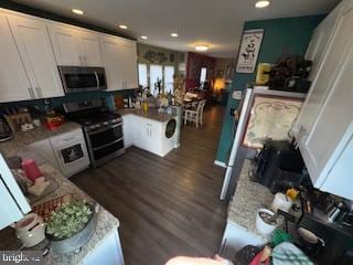 kitchen featuring dark hardwood / wood-style floors, light stone counters, white cabinetry, and appliances with stainless steel finishes