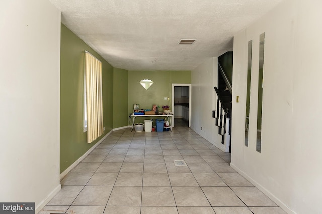 1137 Sycamore St, Camden, NJ 08103 - hallway with light tile patterned floors, a textured ceiling, and baseboards