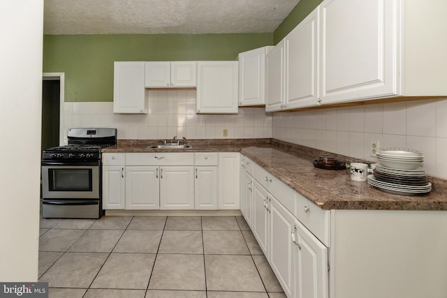 1137 Sycamore St, Camden, NJ 08103 - kitchen with stainless steel range with gas cooktop, a sink, white cabinets, tasteful backsplash, and a textured ceiling
