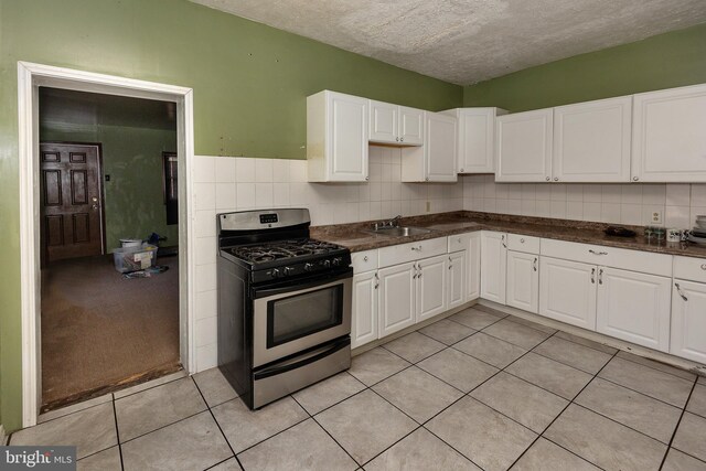 1137 Sycamore St, Camden, NJ 08103 - kitchen featuring stainless steel gas stove, a sink, white cabinetry, dark countertops, and light tile patterned floors