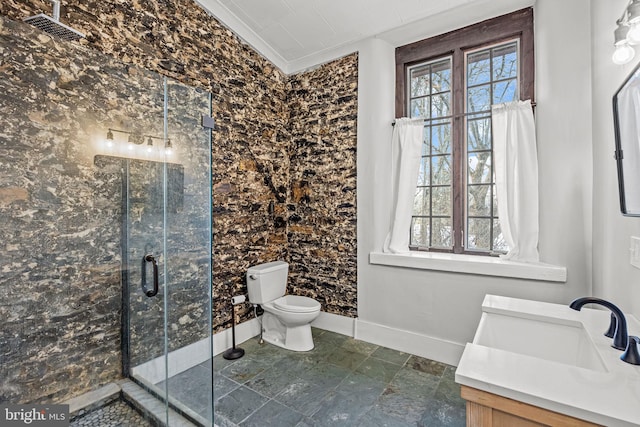 bathroom with vanity, toilet, a shower with shower door, and crown molding