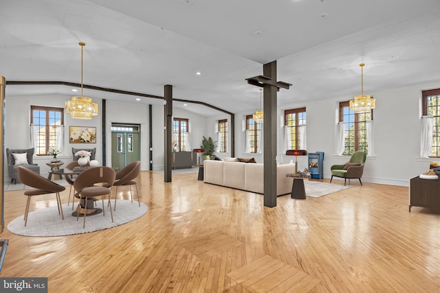 living room with a chandelier, light wood-type flooring, plenty of natural light, and lofted ceiling