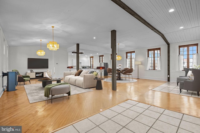 living room featuring a notable chandelier, light hardwood / wood-style floors, and beam ceiling