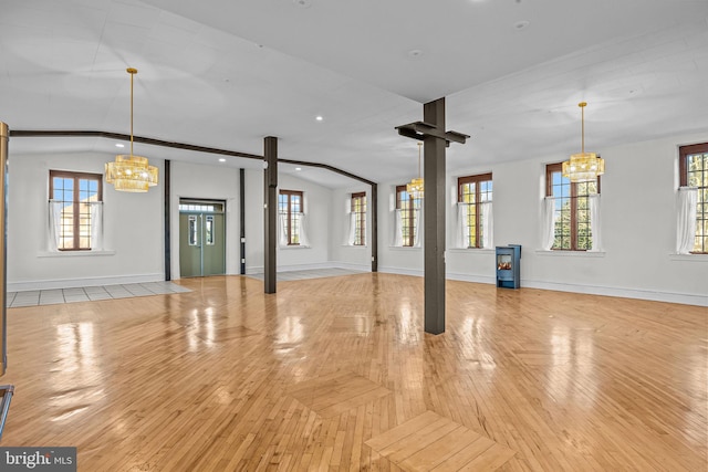 unfurnished living room featuring a notable chandelier and a wealth of natural light