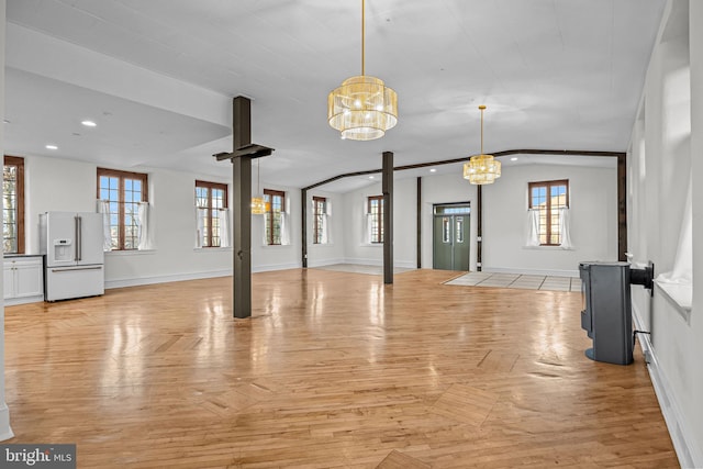 unfurnished living room with light parquet floors and a notable chandelier