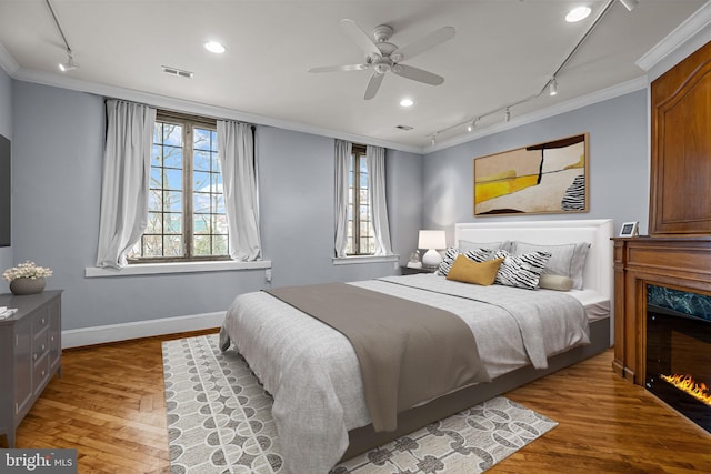 bedroom featuring multiple windows, ceiling fan, and ornamental molding