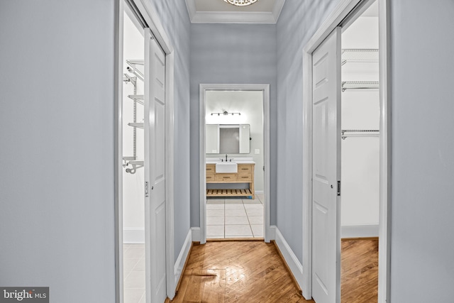 corridor featuring ornamental molding and hardwood / wood-style flooring