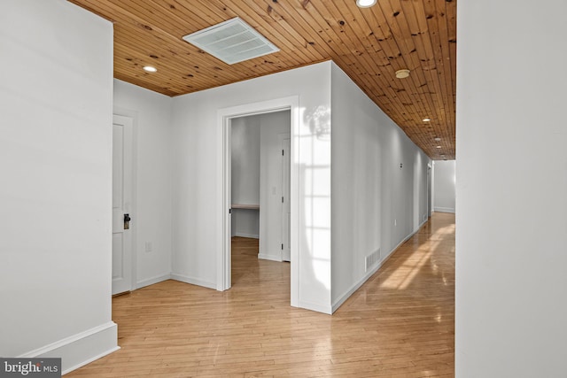 corridor featuring light wood-type flooring and wooden ceiling