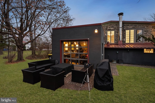 back house at dusk with a lawn