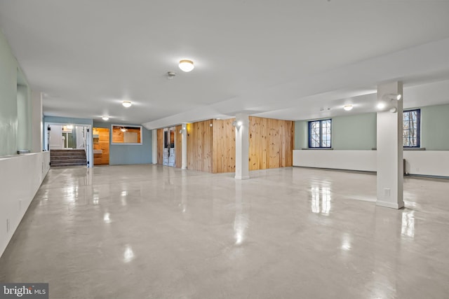 basement featuring wooden walls