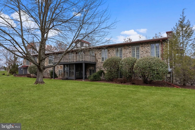 rear view of property with a lawn