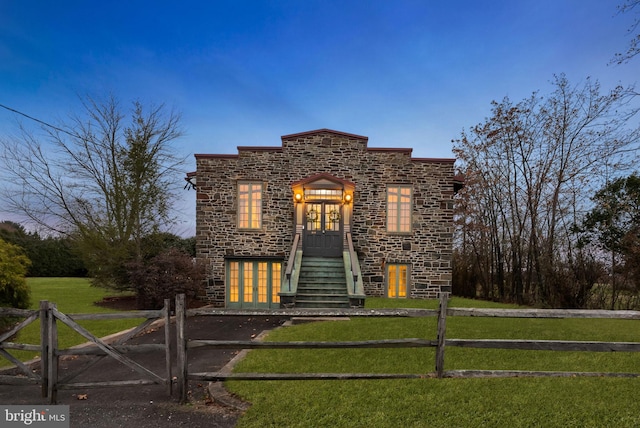 view of front facade with a yard and french doors