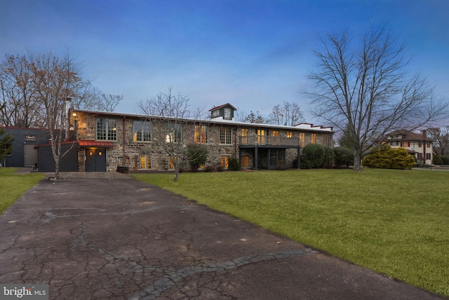 view of front facade featuring a garage, a wooden deck, and a front lawn