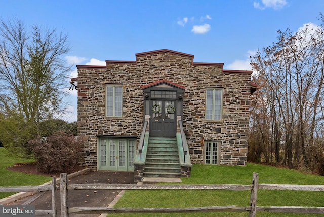 view of front of property featuring a front yard and french doors