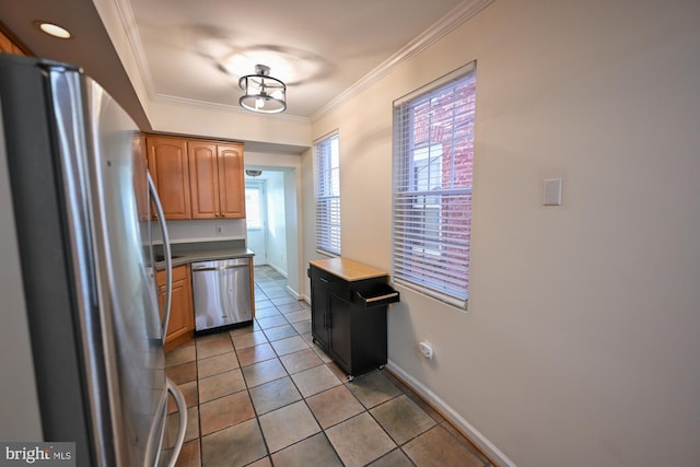 kitchen featuring appliances with stainless steel finishes, light tile patterned floors, and ornamental molding