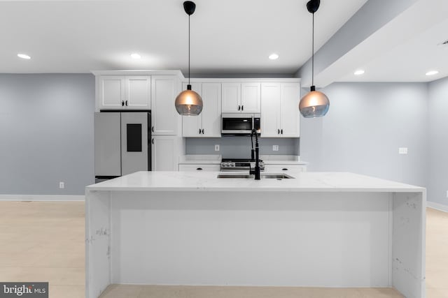 kitchen with light stone countertops, white cabinets, decorative light fixtures, and white refrigerator