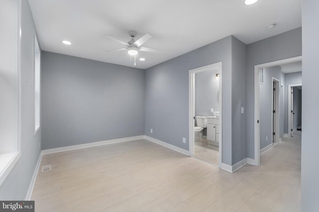 unfurnished bedroom with light wood-type flooring, ensuite bathroom, and ceiling fan